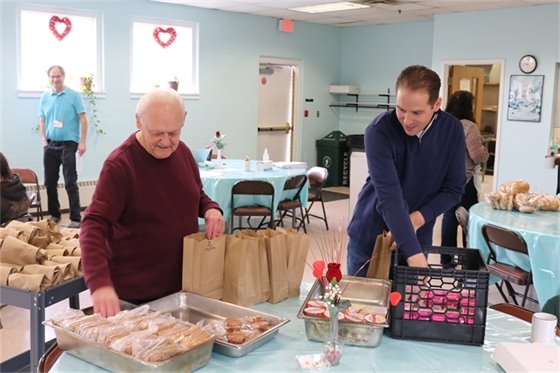 Mayor Perry and a volunteer pack lunches together