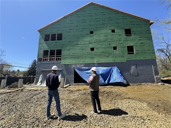 Mayor Tony Perry and Township Administrator Tony Mercantante look at an exterior shot of "Veterans Village".